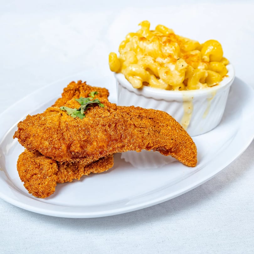 Crispy fried chicken tenders with a side of creamy baked macaroni and cheese.
