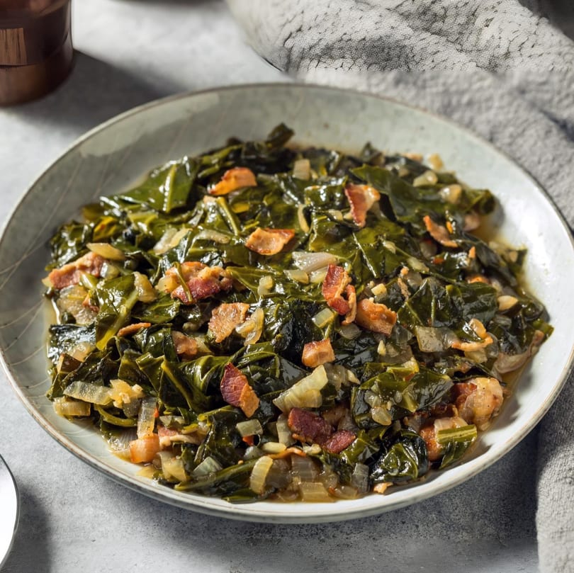 A bowl of MiMi's Craft Kitchen collard greens with bacon and onions.